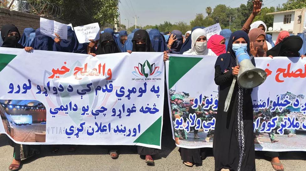 afghan women hold banners and chant slogans in jalalabad during a march to show their support for peace talks between afghan government and the taliban photo afp