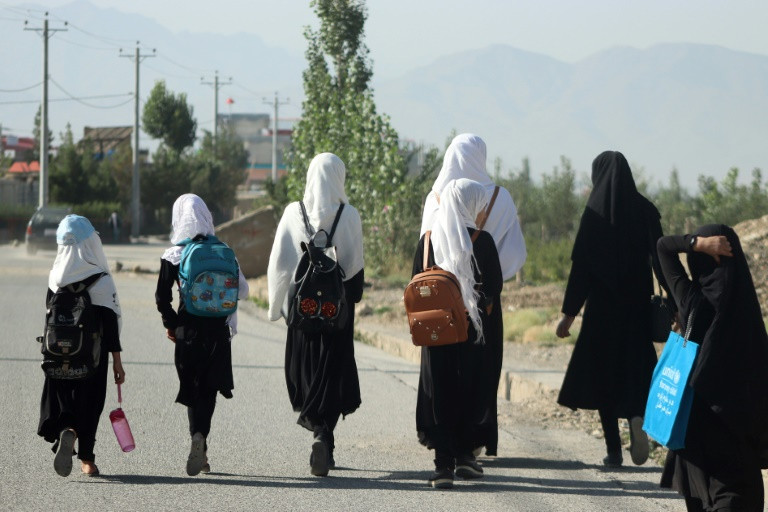 a group of girls head to school in gardez eastern afghanistan five government secondary schools for girls have resumed classes in apparent defiance of a national ban photo afp