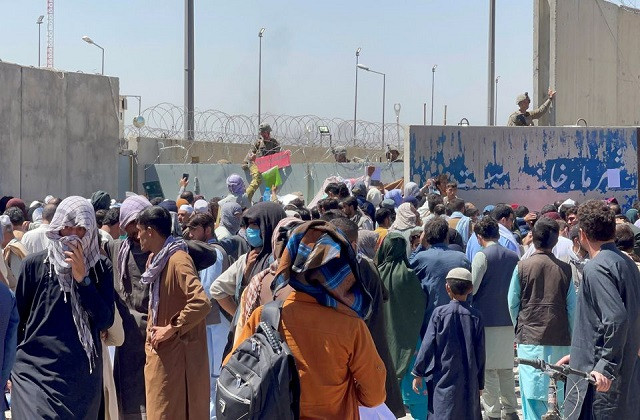 crowds of people show their documents to us troops outside the airport in kabul afghanistan august 26 2021 photo reuters