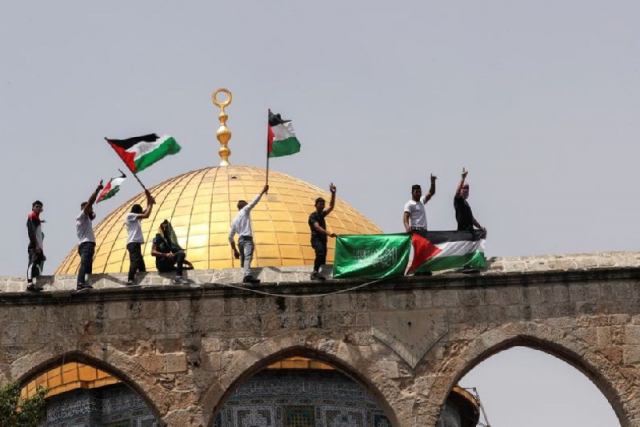 palestinians hold flags as they stand at the compound that houses al aqsa mosque in jerusalem s old city may 21 2021 photo reuters palestinians hold flags as they stand at the compound that houses al aqsa mosque in jerusalem s old city may 21 2021 photo reuters
