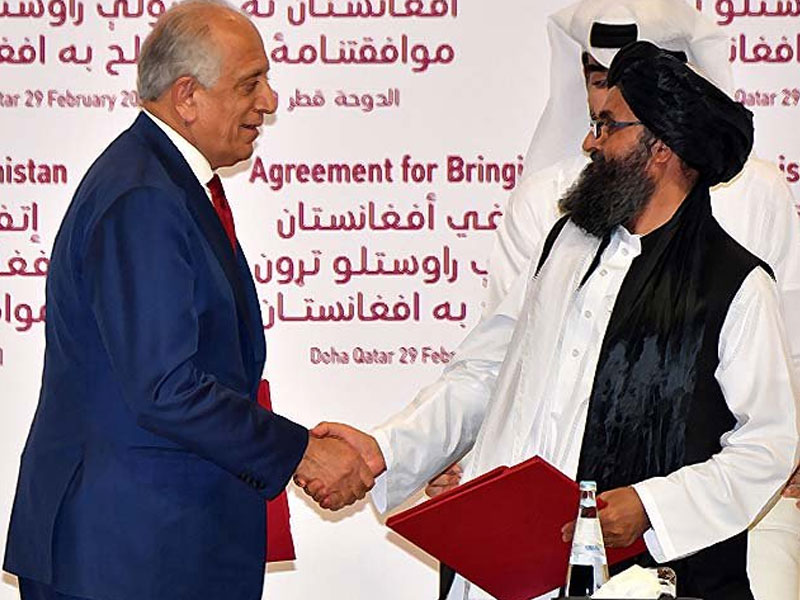 zalmay khalilzad and mullah abdul ghani baradar shake hands photo afp