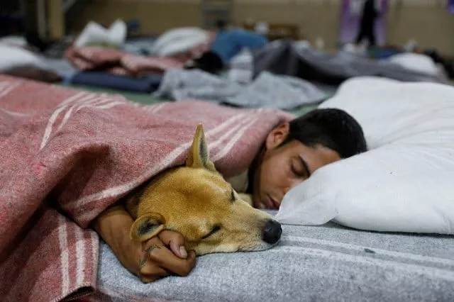 a homeless man embraces his dog while resting in a shelter as low temperatures hit the streets in canoas brazil july 26 2022 photo reuters a homeless man embraces his dog while resting in a shelter as low temperatures hit the streets in canoas brazil july 26 2022 photo reuters