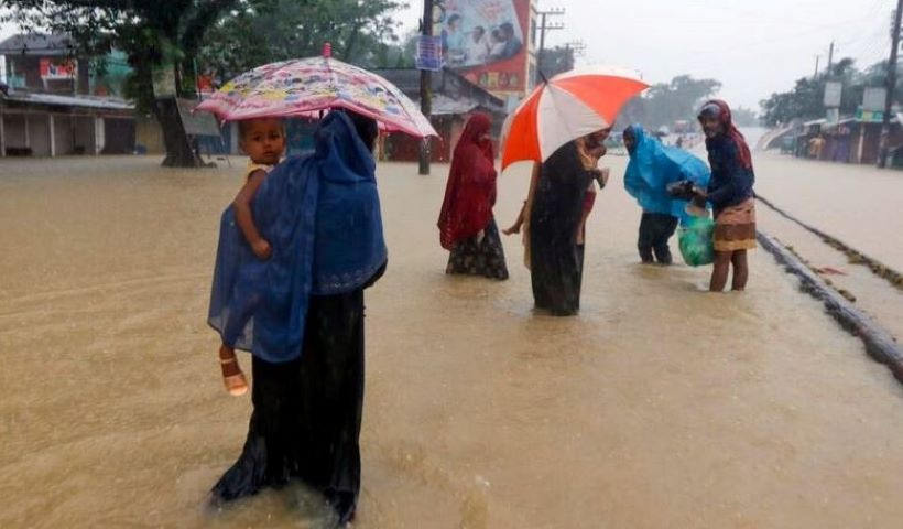 people wade along a flooded road following heavy monsoon rains in sylhet bangladesh   afp