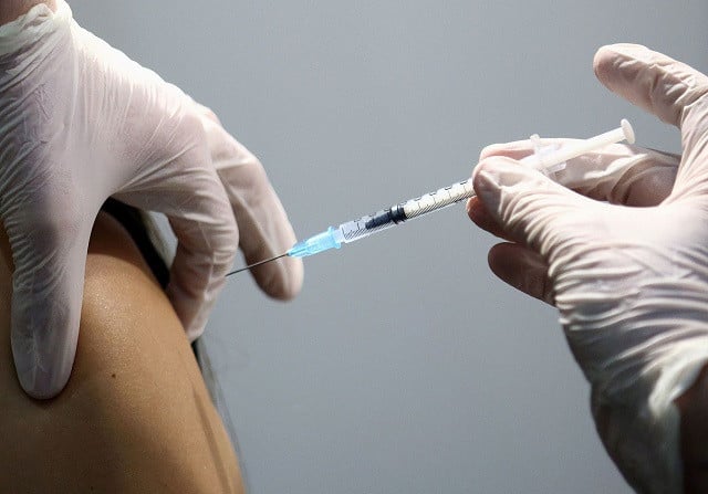 a healthcare worker receives a dose of a pfizer biontech covid 19 vaccine at messe wien congress center which has been set up as a coronavirus disease vaccination centre in vienna austria february 7 2021 photo reuters