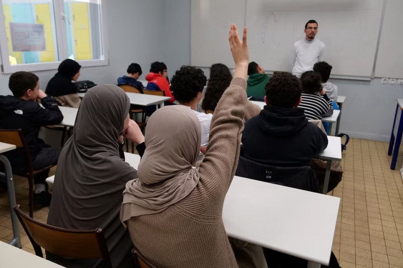 a middle school student raises her hand during an islamic ethics class at the averroes school in lille france march 19 2024 photo reuters