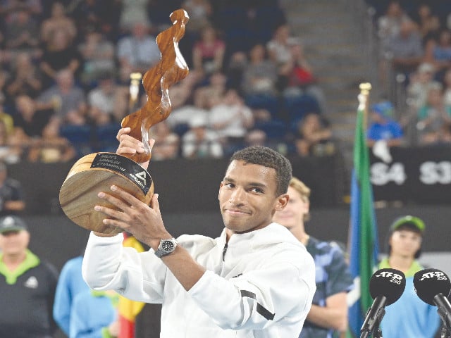 felix auger aliassime lifts the winner s trophy after the men s singles final match against usa s sebastian korda at the adelaide international tennis tournament photo afp