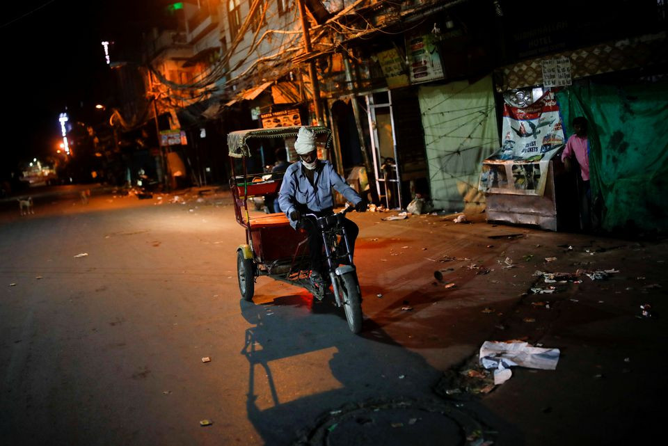 a man rides a rickshaw on a deserted street during a curfew to limit the spread of the coronavirus disease covid 19 in new delhi india april 6 2021 reuters