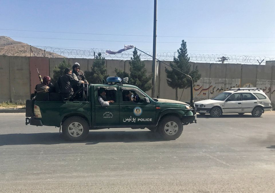 taliban fighters ride on a police vehicle in kabul afghanistan august 16 2021 reuters