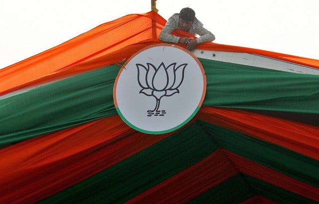 a man installs the symbol of india s ruling bharatiya janata party bjp on a tent during an election campaign rally by the party in prayagraj india february 24 2022 photo reuters