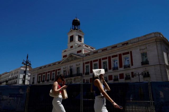 a woman covers her head with a bag as she walks at puerta del sol square during a hot day as spain braces for a heatwave in madrid spain june 10 2022 photo reuters file