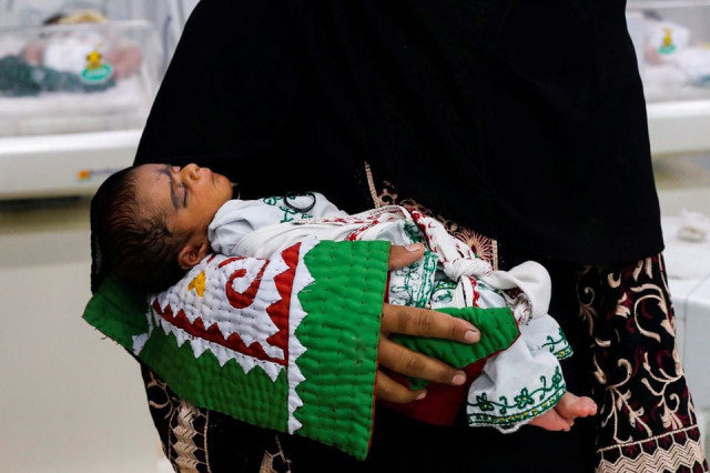 a mother carries her baby while waiting for medical assistance at a hospital following rains and floods during the monsoon season in sehwan pakistan september 7 2022 photo reuters