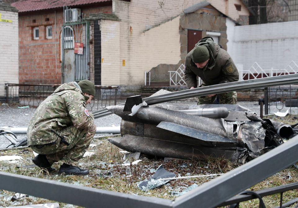 Police officers inspect the remains of a missile that fell in the street, after Russian President Vladimir Putin authorized a military operation in eastern Ukraine, in Kyiv, Ukraine February 24, 2022. REUTERS