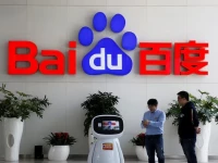 men interact with a baidu ai robot near the company logo at its headquarters in beijing china april 23 2021 photo reuters