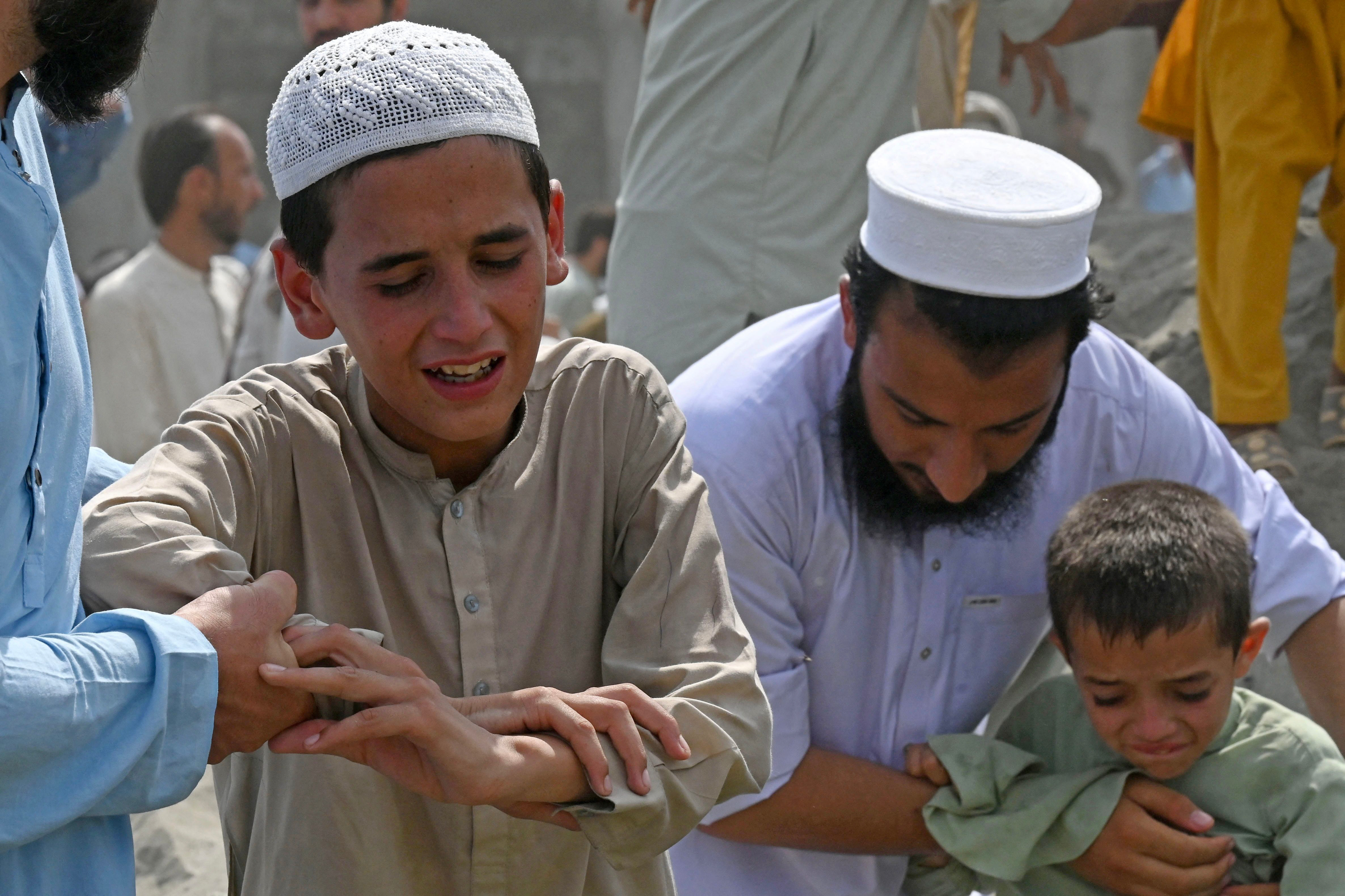 children mourn the death of their family member a day after a suicide bomber unleashed carnage at a jui f workers convention in bajaur district of k p photo afp