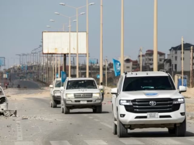 un vehicles drive past a destroyed car on a road in gaza city on apr 1 2024 amid the ongoing battles israel and the hamas militant group photo afp