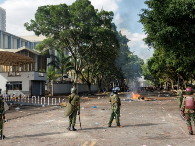 riot police secure parliament buildings near a barricade set alight by protesters photo afp