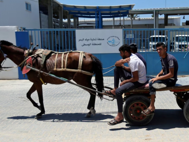 palestinians ride a horse drawn cart past gaza desalination plant in the central gaza strip june 23 2019 photo reuters