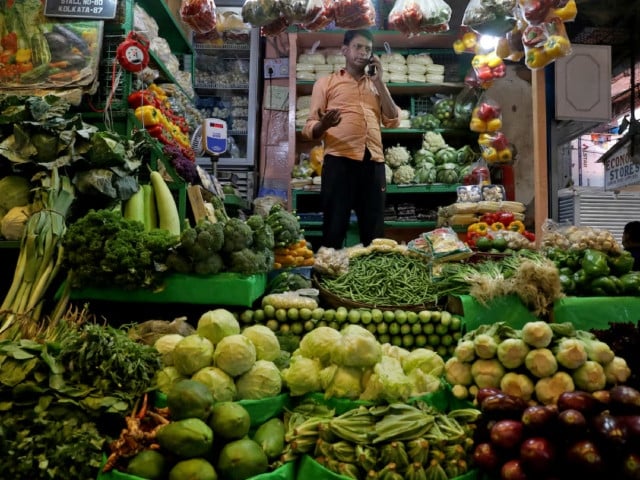 a vegetable vendor speaks on his mobile phone at a retail market area in kolkata india march 22 2022 photo reuters