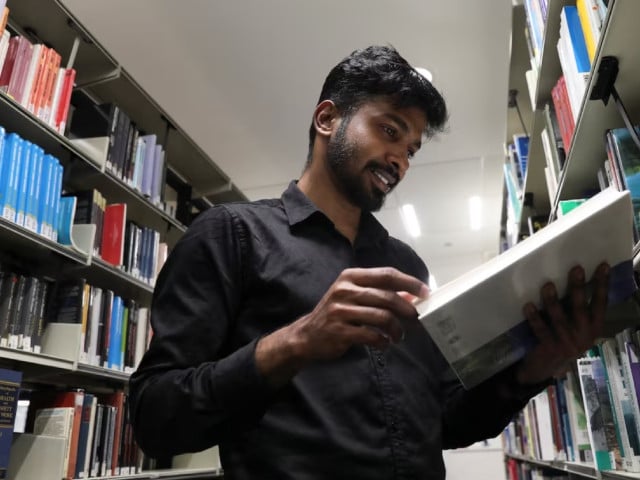 prathesh panjak 27 a first time immigrant voter and post graduate student at the university of salford reads a book at a library ahead of britain s general election in manchester britain june 28 2024 photoi reuters