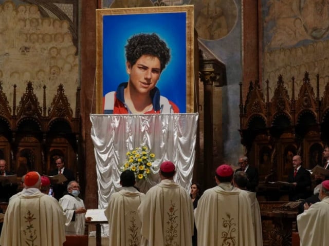 an image of 15 year old carlo acutis is unveiled during his beatification ceremony at the st francis basilica in assisi italy in october 2020 photo npr