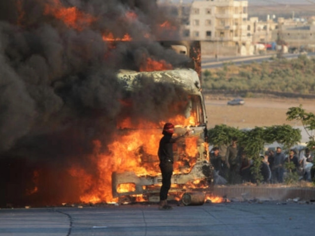 a protester stands in front a burning turkish truck during protests against turkey in a syrian opposition held area north of aleppo photo afp a protester stands in front a burning turkish truck during protests against turkey in a syrian opposition held area north of aleppo photo afp