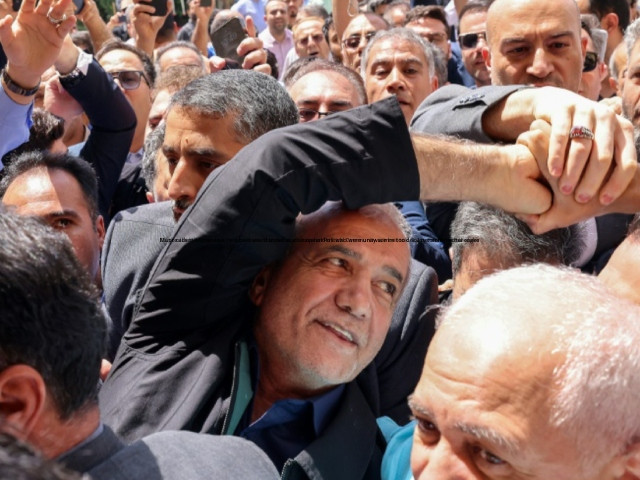 iranian reformist presidential candidate masoud pezeshkian c greets supporters outside a polling station in tehran during the runoff photo afp