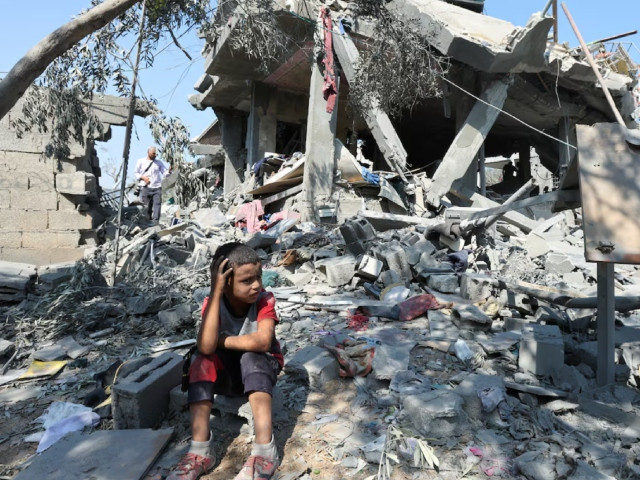 a child sits amid the rubble as palestinians inspect a house destroyed in an israeli strike amid the israel hamas conflict in nusairat refugee camp in the central gaza strip july 9 2024 photo reuters