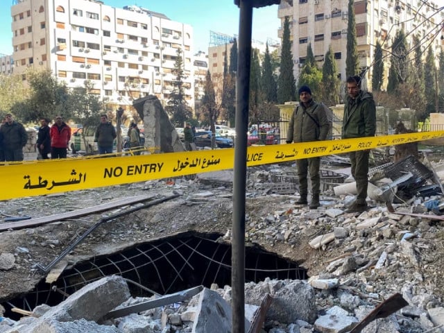police officers stand on the rubble of a damaged building at the site of a rocket attack in central damascus kafr sousa neighborhood syria february 19 2023 photo reuters