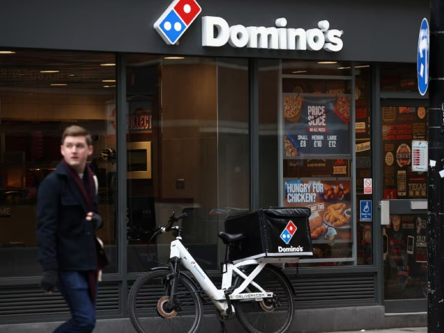 a person walks past a domino s pizza restuarant in london britain march 4 2023 photo reuters