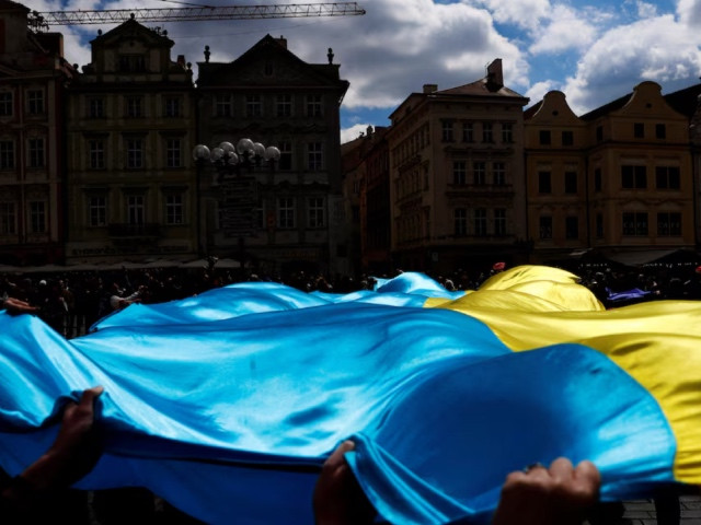 people hold a ukrainian flag during a rally in support of estonia s military strategy plan to help ukraine in prague czech republic april 21 2024 photo reuters