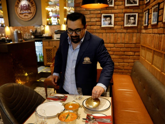 amit bagga ceo of daryaganj restaurant shows a freshly prepared butter chicken dish and the lentil dish dal makhani inside daryaganj restaurant at a mall in noida india january 23 2024 photo reuters