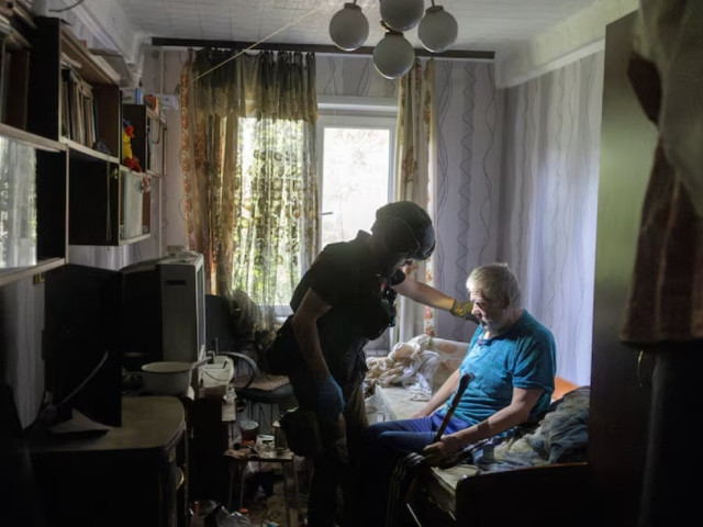 a volunteer of east sos assists resident andrii ostorozhnyi who is evacuating his home because of russian advances amid russia s attack on ukraine in selydove near pokrovsk ukraine august 22 2024 photo reuters