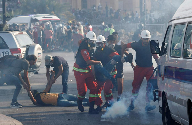 a demonstrator holds a lebanese flag as another hurls stones during a protest following tuesday s blast in beirut lebanon august 8 2020 photo reuters a demonstrator holds a lebanese flag as another hurls stones during a protest following tuesday s blast in beirut lebanon august 8 2020 photo reuters