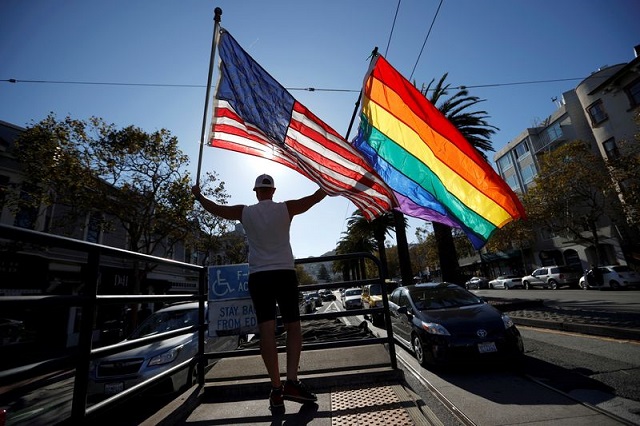 Bob Henson waves a rainbow flag and a US national flag as people celebrate in the Castro district after news media declared US presidential nominee Joe Biden the winner of the 2020 US presidential election in San Francisco, California, US November 7, 2020. PHOTO: REUTERS