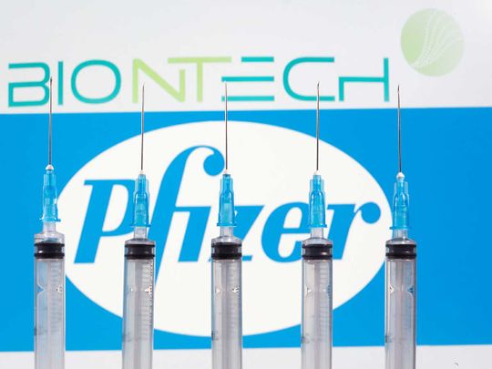 syringes are seen in front of displayed biontech and pfizer logos in this illustration taken november 10 2020 reuters