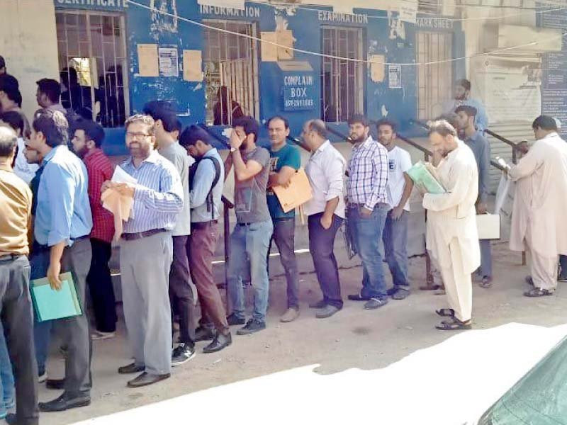 students stand in a queue at the board of intermediate education karachi office photo file