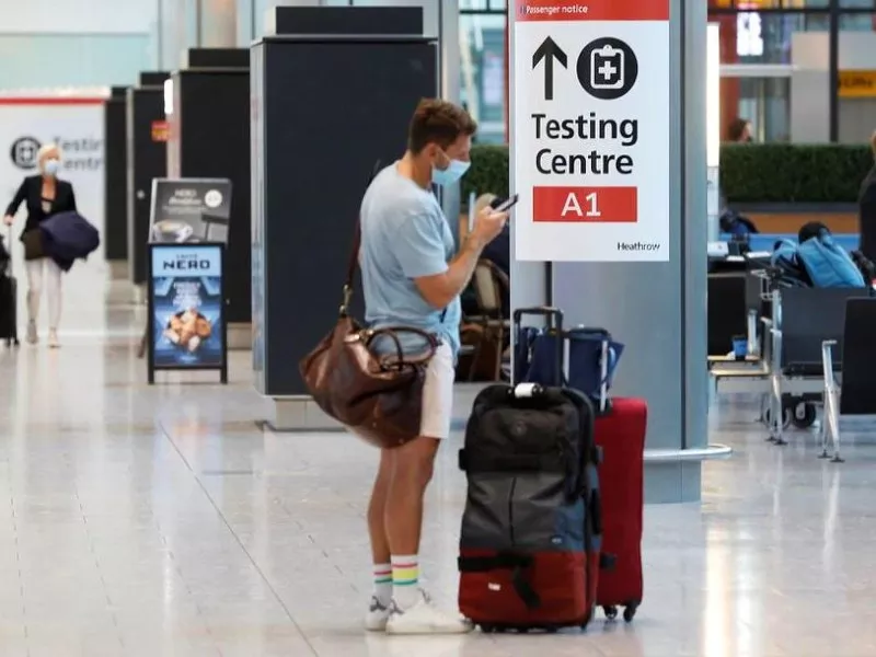 a passenger stands next to a covid 19 testing centre sign in the international arrivals area of terminal 5 in london s heathrow airport britain august 2 2021 photo reuters file a passenger stands next to a covid 19 testing centre sign in the international arrivals area of terminal 5 in london s heathrow airport britain august 2 2021 photo reuters file