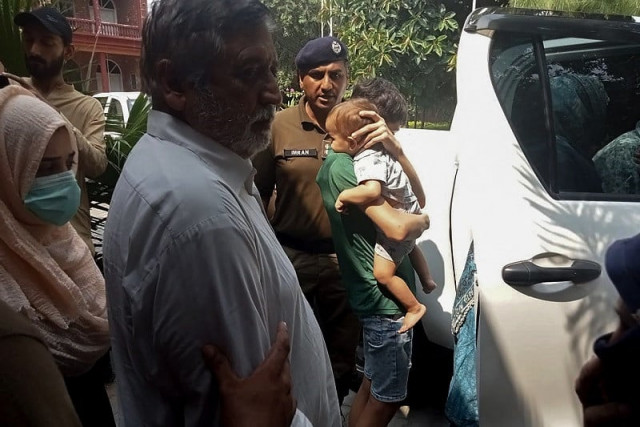 police personnel escort british pakistani children r and their grandfather muhammad sharif 3l after appearing in a local court in jhelum on september 12 2023 photo afp