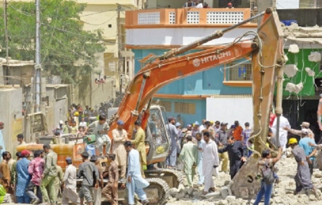 karachi metropolitan corporation workers use heavy machinery to tear down structures deemed illegal during an on going anti encroachment operation in orangi town photo online