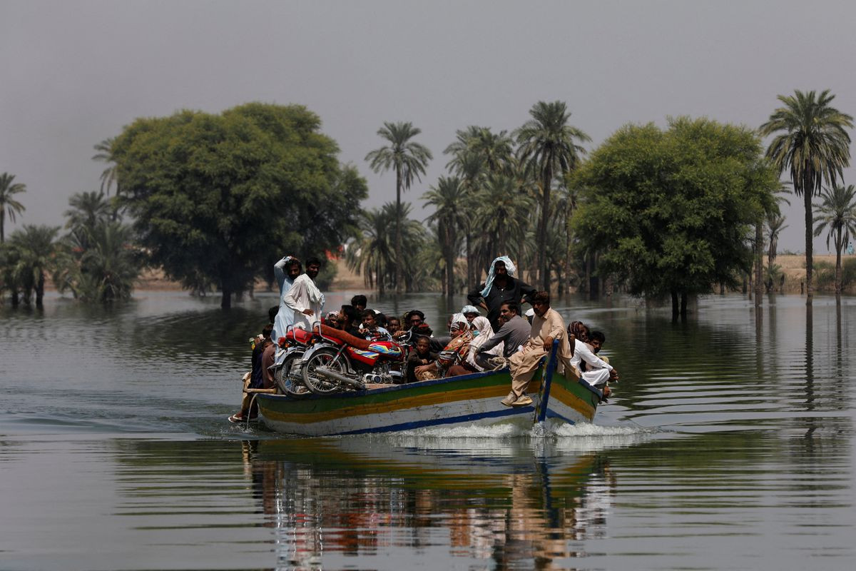 flood victims travel in a boat following rains and floods during the monsoon season in talti town in sehwan pakistan september 15 2022 photo reuters file