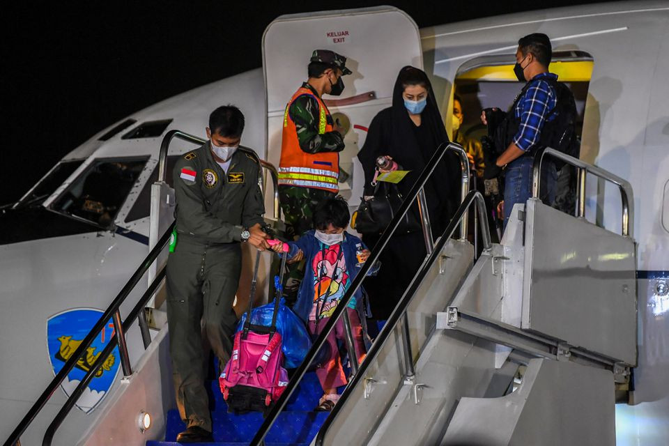 an indonesian airforce personnel helps a girl down the stairs of the aircraft as indonesian citizens who were evacuated from kabul afghanistan arrive at halim perdanakusuma airbase in jakarta indonesia august 21 2021 in this photo taken by antara foto photo reuters