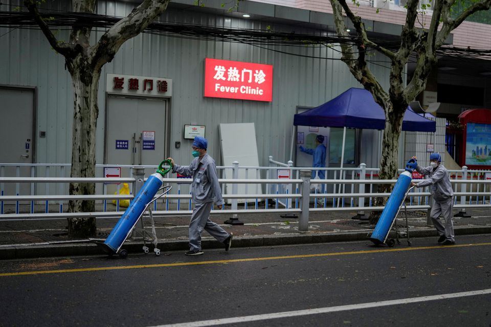 workers deliver oxygen cylinders outside a hospital during lockdown amid the coronavirus disease covid 19 pandemic in shanghai china april 14 2022 photo reuters