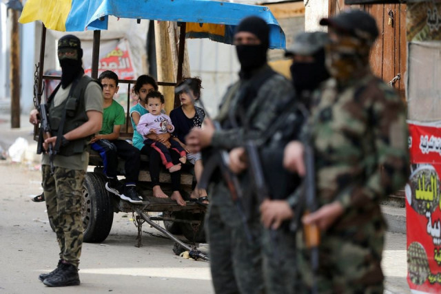 palestinian children look on as islamic jihad stand guard following israel hamas truce in gaza photo reuters palestinian children look on as islamic jihad stand guard following israel hamas truce in gaza photo reuters