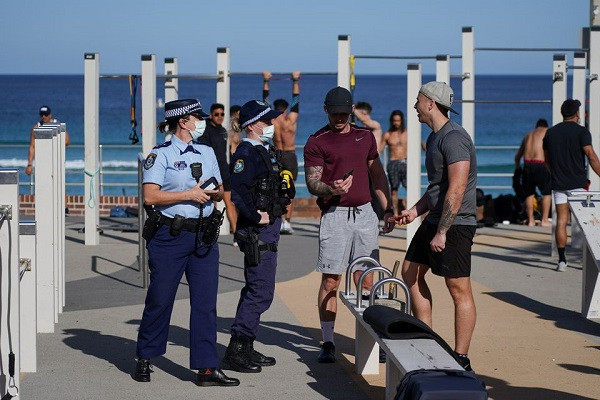 patrolling police officers check id information of people working out at a bondi beach outdoor gym area during a lockdown to curb the spread of a coronavirus disease covid 19 outbreak in sydney australia july 27 2021 photo reuters