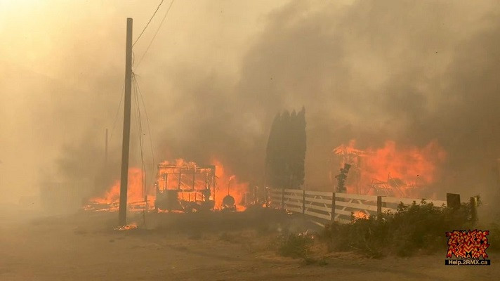 flames rise from a burning building along a street during a wildfire in lytton british columbia canada june 30 2021 in this still image obtained from a social media video on july 1 2021 photo reuters