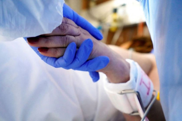 a medical specialist holds the hand of a patient suffering from the coronavirus disease covid 19 at the intensive care unit icu of toxicology and sepsis clinic of the riga east clinical university hospital in riga latvia photo reuters a medical specialist holds the hand of a patient suffering from the coronavirus disease covid 19 at the intensive care unit icu of toxicology and sepsis clinic of the riga east clinical university hospital in riga latvia photo reuters