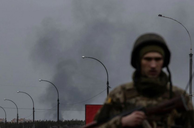 smoke rises as a service member of the ukrainian armed forces stands by the only escape route used by locals to evacuate from the town of irpin after days of heavy shelling while russian troops advance towards the capital in irpin near kyiv ukraine march 7 2022 photo reuters smoke rises as a service member of the ukrainian armed forces stands by the only escape route used by locals to evacuate from the town of irpin after days of heavy shelling while russian troops advance towards the capital in irpin near kyiv ukraine march 7 2022 photo reuters