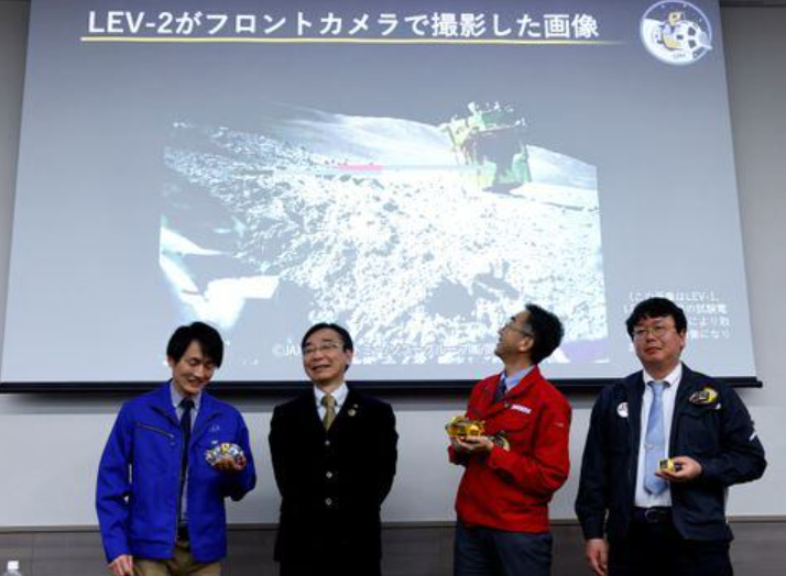 daichi hirano hitoshi kuninaka shinichiro sakai and masatsugu otsuki from the japan aerospace exploration agency jaxa smile in front of a screen showing an image taken by lev 2 on the moon after their press conference on slim s moon landing mission in tokyo japan january 25 2024 photo reuters