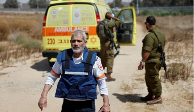 an israeli medic walks near soldiers and an ambulance after palestinian islamist group hamas claimed responsibility for an attack on kerem shalom crossing near israel s border with gaza in southern israel may 5 2024 reuters amir cohen