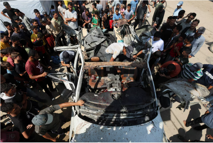 palestinians inspect a vehicle hit in an israeli strike amid israel hamas conflict in deir al balah in the central gaza strip june 4 2024 reuters ramadan abed